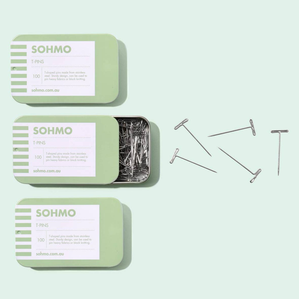 Three green tins labeled 'SOHMO' with pins on a light green background