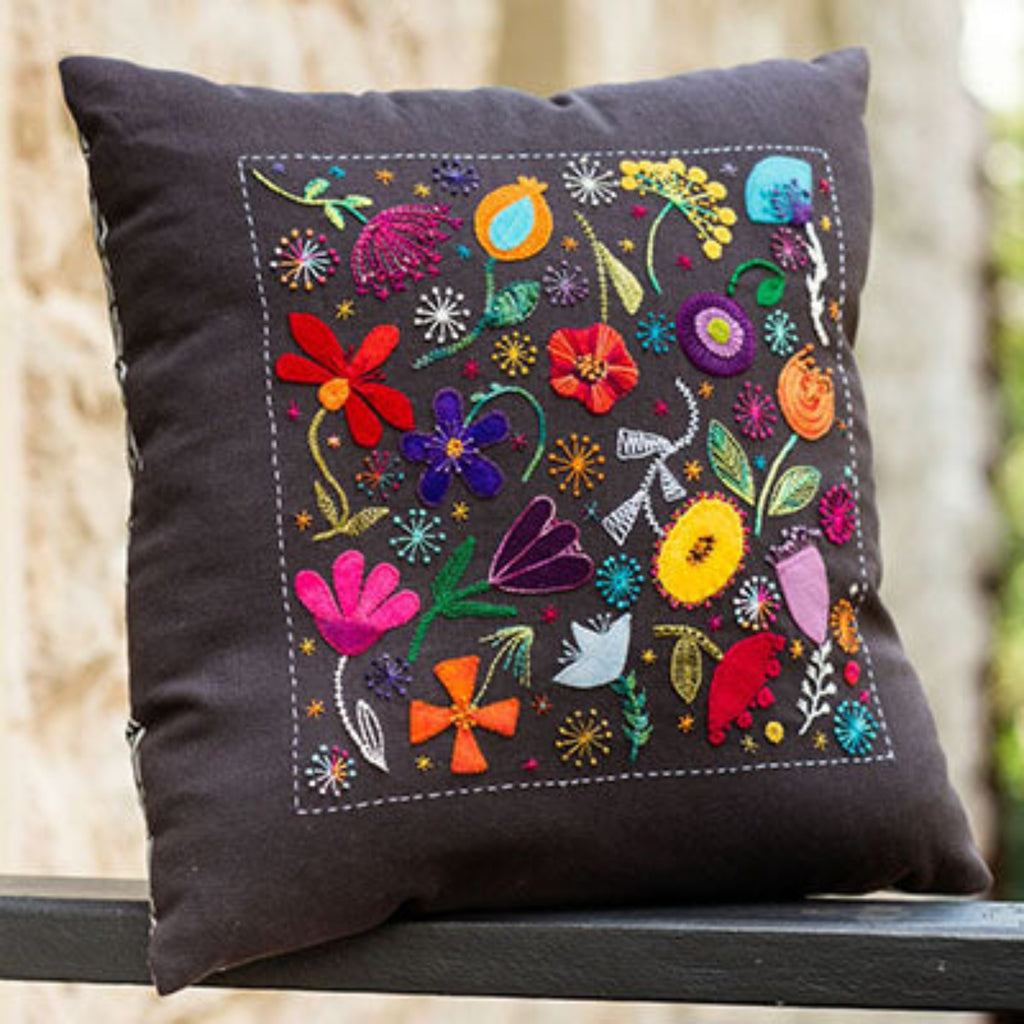Decorative pillow with colorful floral embroidery on a black background
