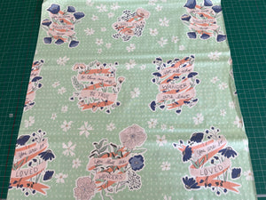 Fabric with decorative patterns and text on a green background