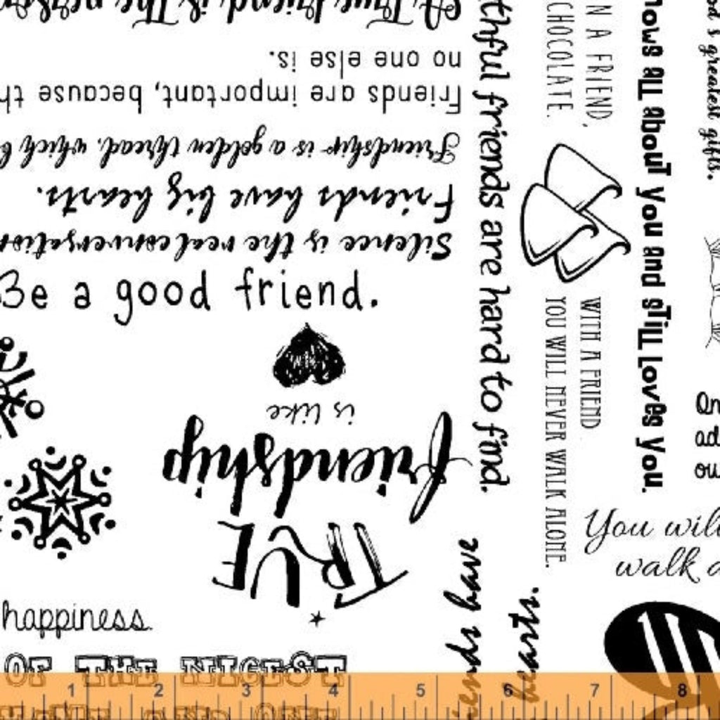 A piece of fabric from the 'Be Mindful, Friendship' collection by Whistler Studios, featuring a variety of written phrases in different fonts and sizes on a black background.