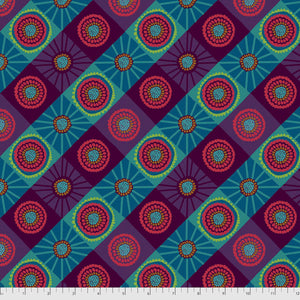 A piece of fabric featuring a geometric pattern with brightly colored circles and dots, predominantly in shades of blue and green, with a mountain-like border design.