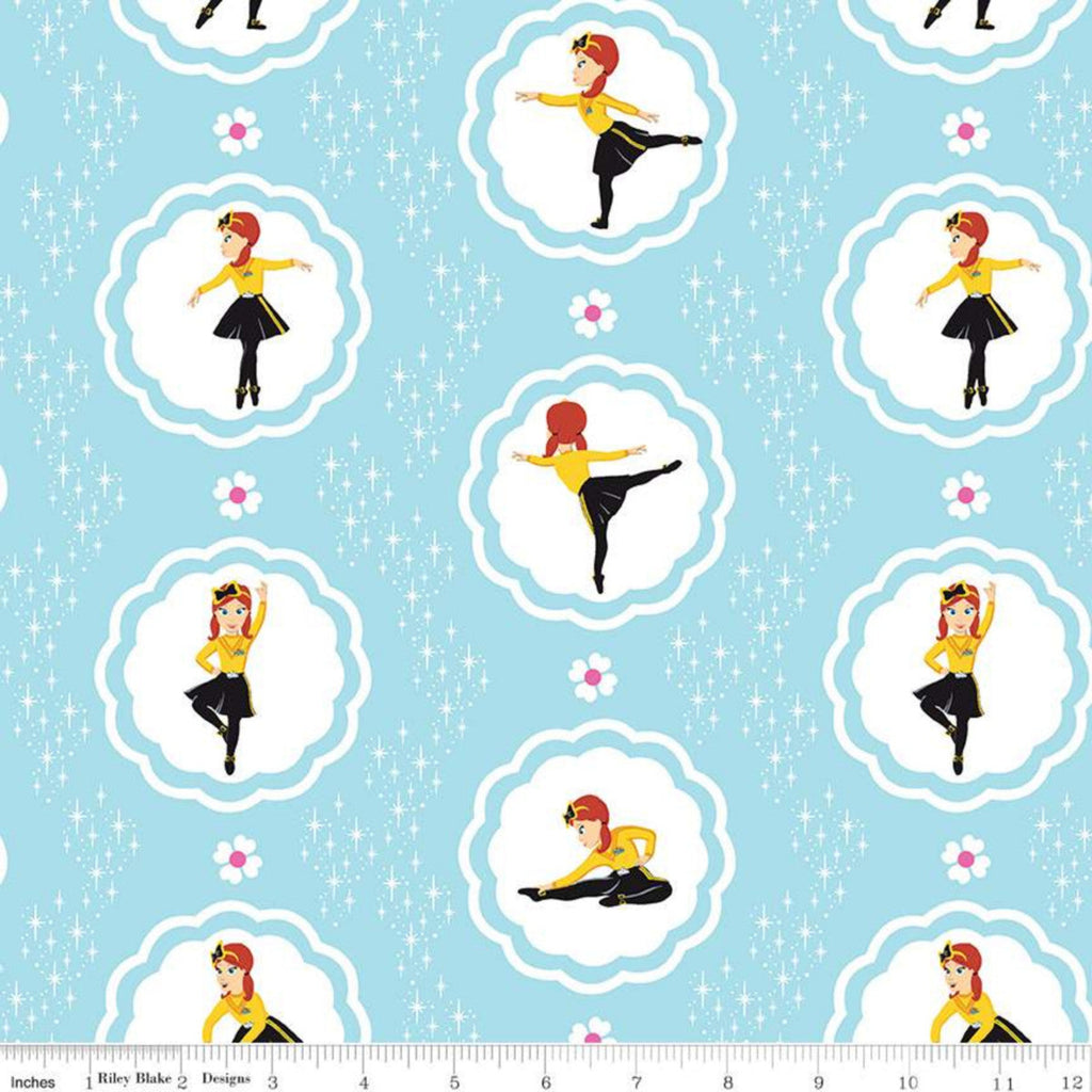 Fabric featuring character illustrations of Emma Watkins from The Wiggles in various dancing poses, surrounded by scalloped circles on a blue background with stars and flowers.