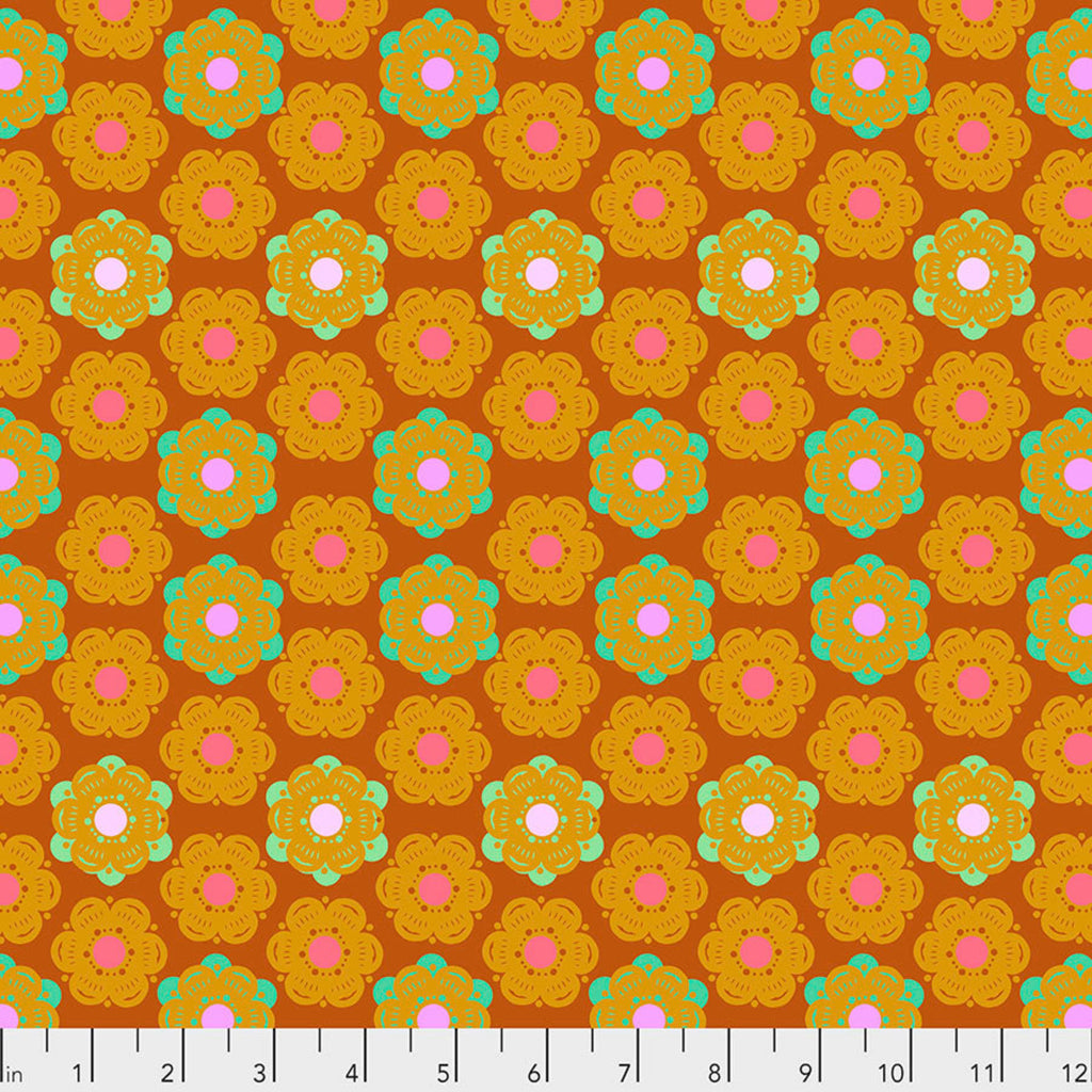 A fabric featuring a geometric honeycomb pattern with a sunset color palette of orange, yellow, and pink.