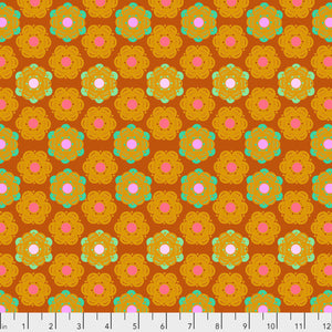A fabric featuring a geometric honeycomb pattern with a sunset color palette of orange, yellow, and pink.