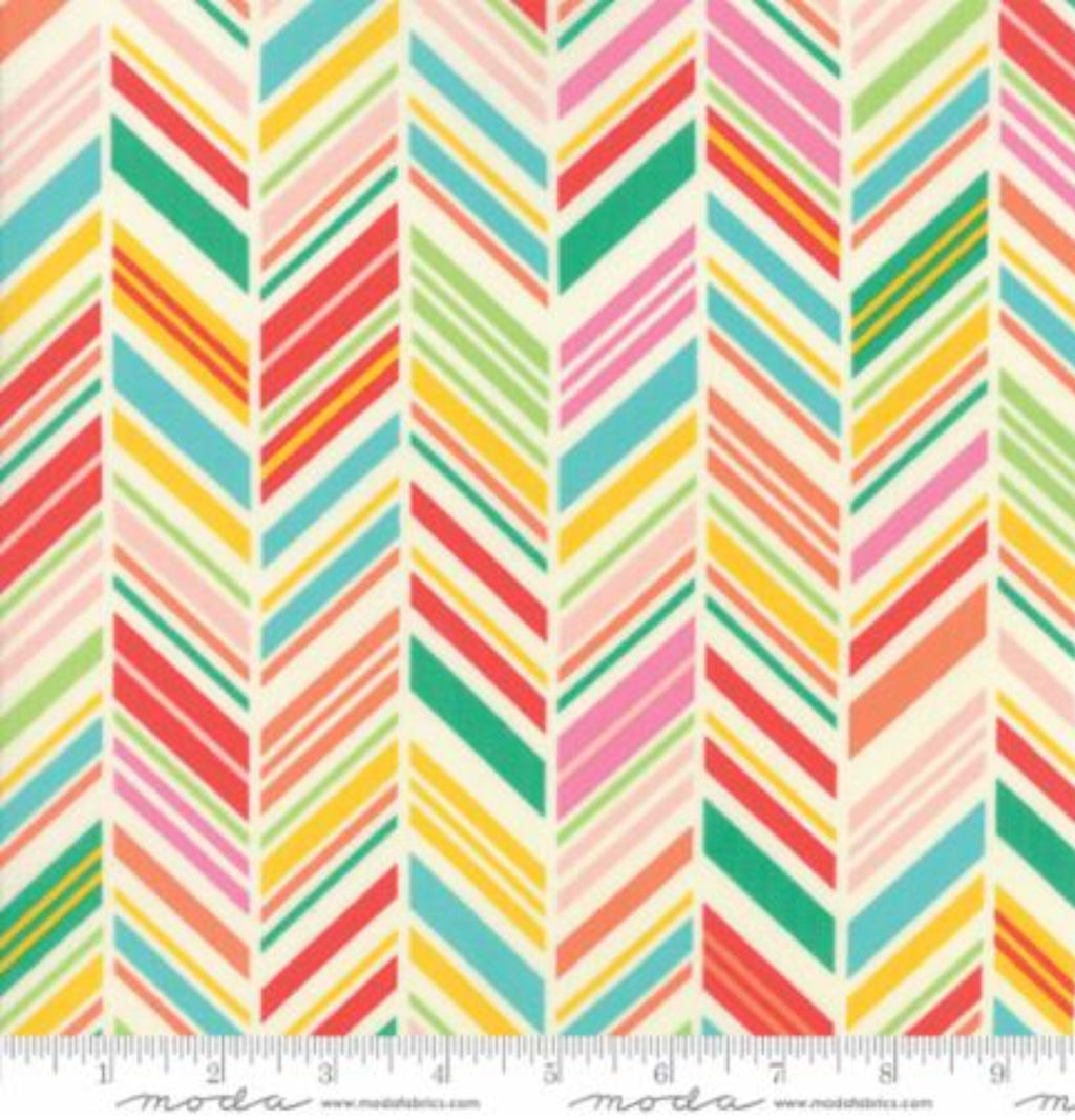 A canvas fabric with a multicolored floral pattern, predominantly featuring red, green, and yellow, with a sunset theme.